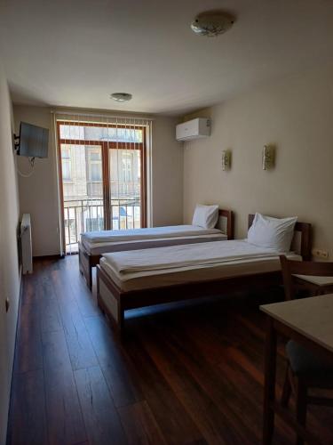 特罗扬Семеен хотел МАРС的带大窗户的客房内的两张床