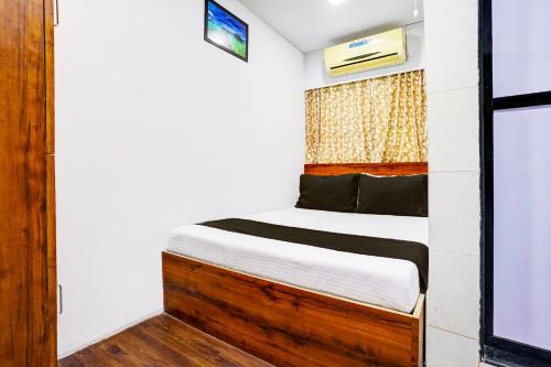 孟买Hotel Metro House的一个小房间的一个床位,设有窗户