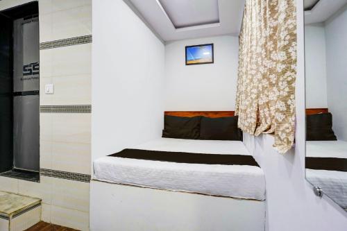 孟买Hotel Metro House的一间小卧室,配有床和窗户