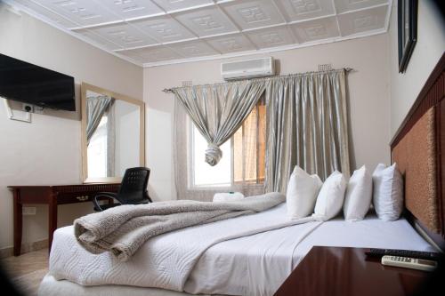 恩多拉Fatmols City Hotel的一间卧室配有一张床、一张书桌和一个窗户。