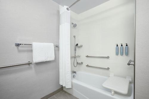 马里兰高地圣路易斯西港广场万怡酒店的带浴缸、卫生间和盥洗盆的浴室