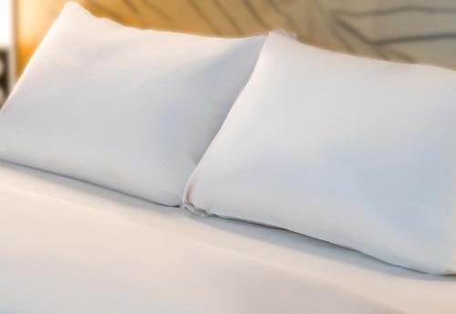 圣维斯B&B HOTEL Saint-Witz Roissy的床上的白色枕头