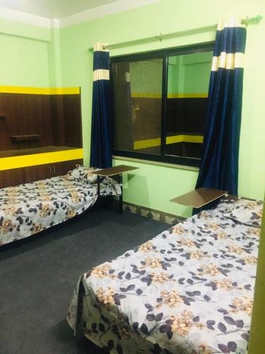 加德满都Om Kedareshwar Boys Hostel的客房设有两张床和窗户。