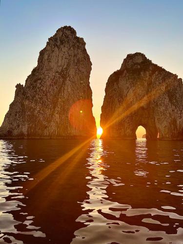 卡普里U sea Capri的水中的一个拱,太阳在两块岩石之间