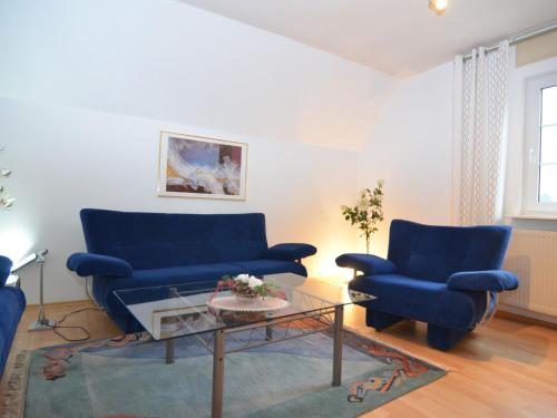 梅舍德Apartment near ski area in Wehrstapel in Sauerland的客厅配有2张蓝色的沙发和1张桌子