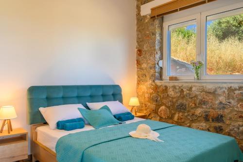 阿基欧斯尼古拉斯Althea Villa by breathtaking view的一间卧室配有一张蓝色的床,上面有帽子