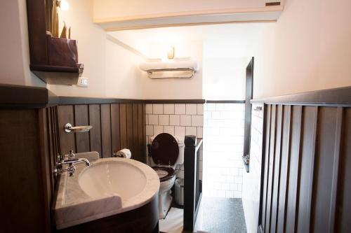曼谷1905年遗产角落旅馆的一间带水槽和卫生间的浴室