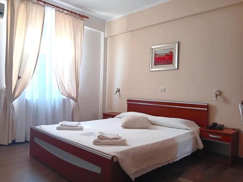 蒂米什瓦拉Hotel vila veneto的一间卧室设有一张床和一个窗口