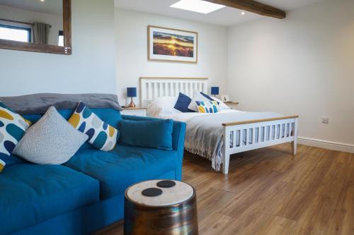 格拉斯顿伯里Conkers - a new bespoke rural escape near Glastonbury的客厅配有蓝色的沙发和床。