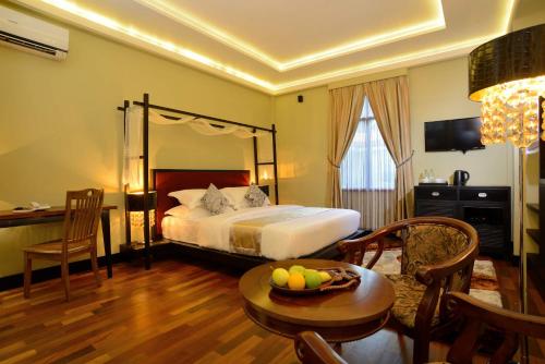 FuvahmulahFuvahmulah Central Hotel的酒店客房,配有一张床和一张桌子,还有一碗水果