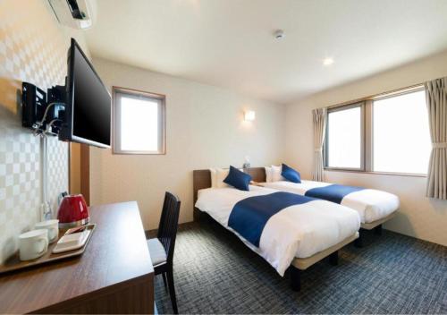 京都HOTEL DORIA的酒店客房配有两张床和一张书桌