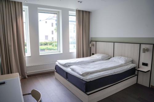 诺尔雪平诺尔雪平舒适酒店的一张位于带大窗户的房间内的床铺
