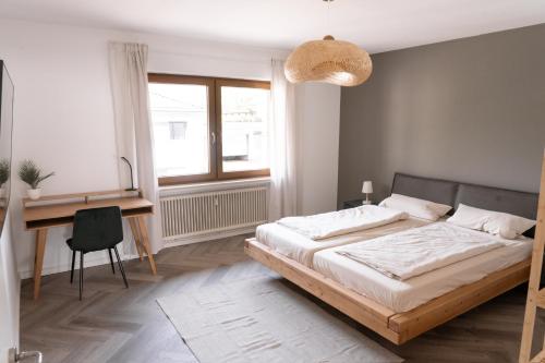 TrierweilerTRIMOSA Apartments - cozy, modern und citynah的一间卧室配有一张床、一张书桌和一张书桌