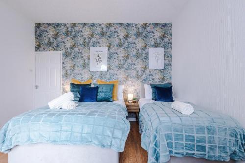 曼彻斯特Beautiful 2 Bedroom House in Manchester Sleeps 7 with Wi-Fi的一间卧室配有两张带蓝色棉被的床