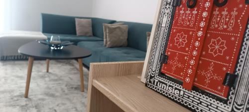 DrariaLogement Chic, résidence azaléa - Alger的客厅配有蓝色的沙发和桌子