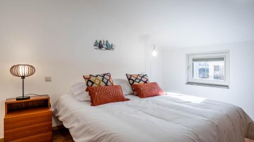 波瓦-迪瓦尔津Casas do Pescador by LovelyStay的卧室配有带枕头的白色床和窗户。