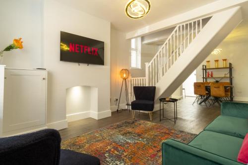 HugglescoteSparkenhoe House的客厅配有沙发和墙上的电视