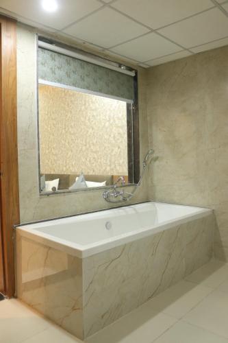 瓜廖尔Hotel maxsun gwalior的浴室配有浴缸及镜子