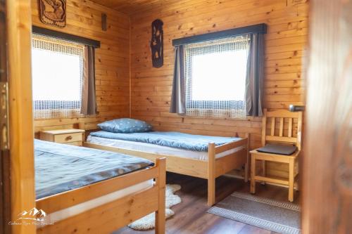 BorzontRum Haz的小木屋内一间卧室,配有两张床