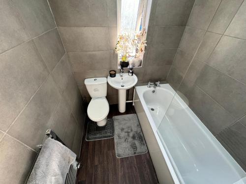 考文垂Home In Coventry的浴室配有卫生间、盥洗盆和浴缸。
