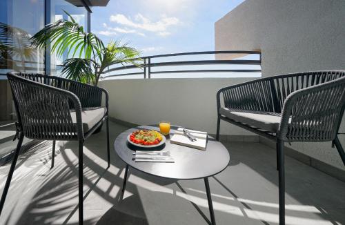 阿德耶Labranda Suites Costa Adeje的阳台上的餐桌上放着一碗食物