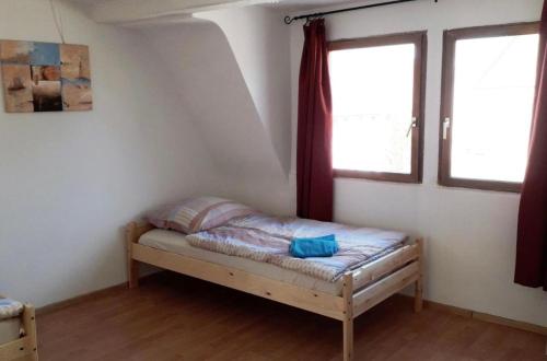 莱奇根home2stay Worker House Feldstetten Kitchen,Wifi,Smart TV Parking ***的一张小床,位于带两个窗户的房间