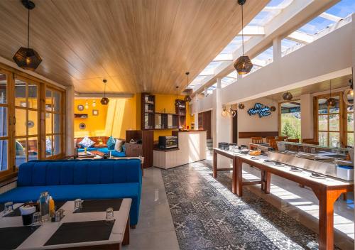 马拉里Moustache Manali的大型客厅配有蓝色的沙发和桌子