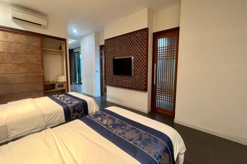 清迈Thai Good Arts Resort的酒店客房设有两张床和一台平面电视。