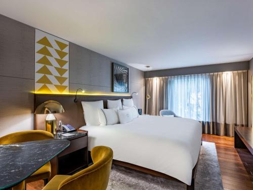 波哥大波哥大维多利亚雷吉亚索菲特酒店的酒店客房设有一张大床和一张书桌。