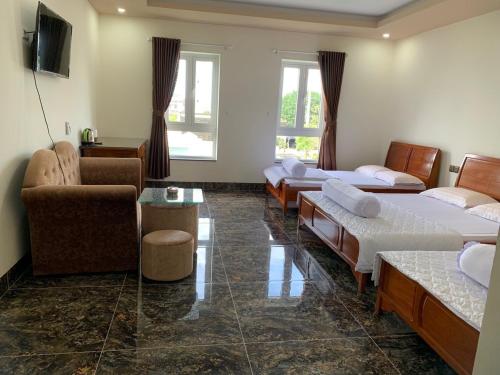Bạc LiêuHOÀNG GIA BẠC LIÊU的客房设有三张床、一张沙发和一张桌子