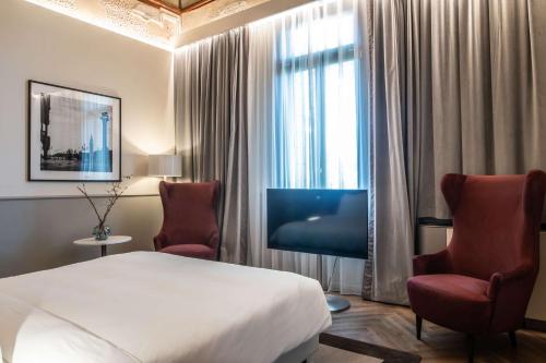 威尼斯Radisson Collection Hotel, Palazzo Nani Venice的酒店客房,配有一张床和两把椅子