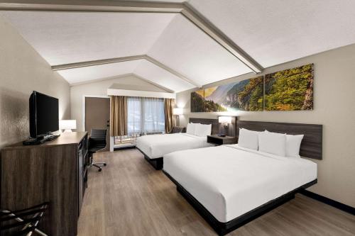 RhinelanderClarion Pointe Rhinelander Downtown的酒店客房设有两张床和一台平面电视。