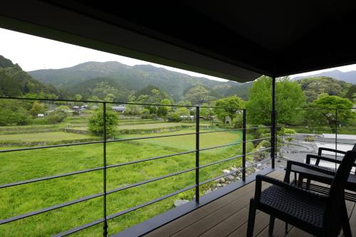 朝仓Akizukinoyado Tsuki No Hanare的阳台设有2张长椅,享有山谷美景。