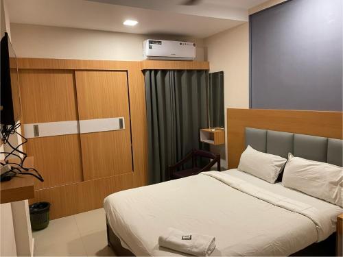 科泽科德Select Residency的酒店客房设有一张床和一个衣柜。