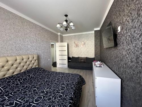 巴尔喀什1 комн.квартира的一间卧室配有一张床和一张沙发