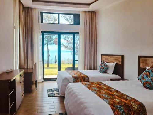 Eben Lake Kivu cottages and Villas的酒店客房设有两张床和窗户。