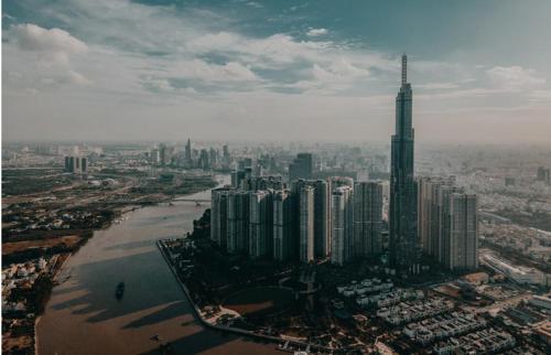 胡志明市Merry Land LANDMARK 81的享有河流和摩天大楼城市的空中景致