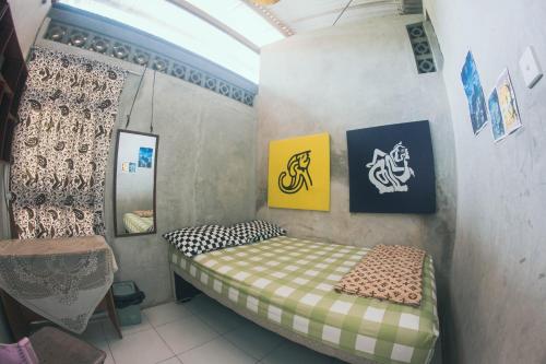 玛琅Condro Wulan Hostel的一间小卧室,配有一张床和镜子