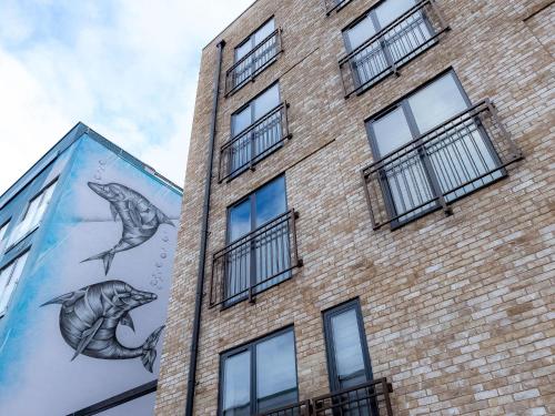 伦敦Luxurious Apartments Hackney near Train Station的一座砖砌的建筑,上面有海豚壁画