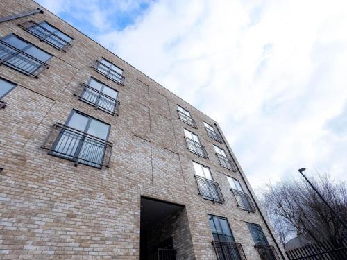 伦敦Luxurious Apartments Hackney near Train Station的一面设有窗户的砖砌建筑