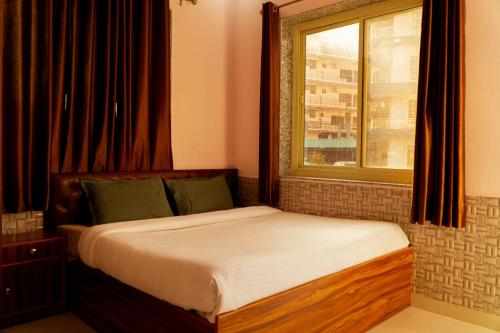 瑞诗凯诗Shanti Hostel Rishikesh的窗户客房内的一张床位