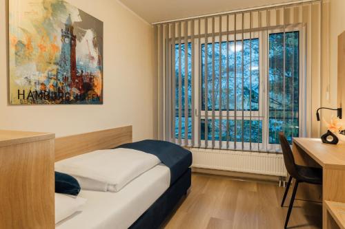 汉堡MYKY Hotel Boardinghouse的卧室配有一张床、一张书桌和窗户。