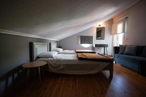 凯尔法温泉凯法司湖酒店的一间卧室配有一张床和一张蓝色的沙发