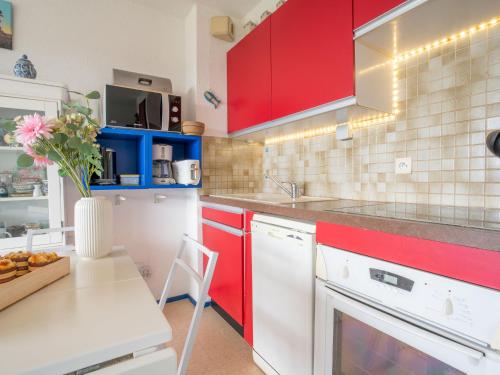 基伯龙Apartment Plein Sud-1 by Interhome的厨房配有红色橱柜和花瓶桌子