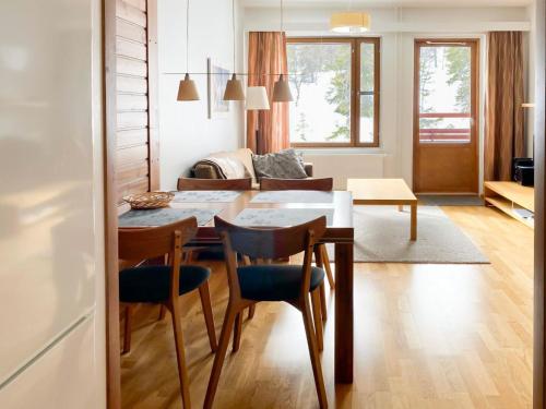 于莱Holiday Home Ylläs chalets a307 by Interhome的厨房以及带桌椅的起居室。