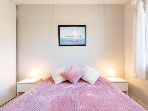 米尼赞海滩Apartment Les Pêcheurs-4 by Interhome的一间卧室配有一张粉红色的床和两盏灯