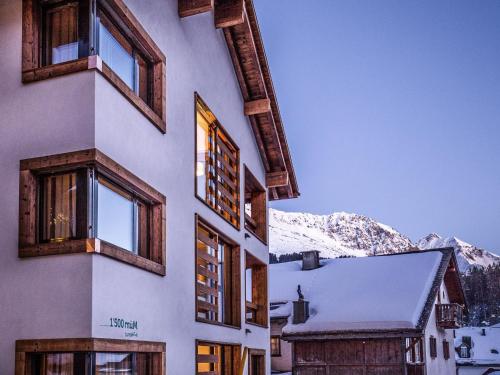 帕尔潘Apartment Turrabuel 7-Bett Deluxe by Interhome的一座带窗户和雪覆盖的山的建筑