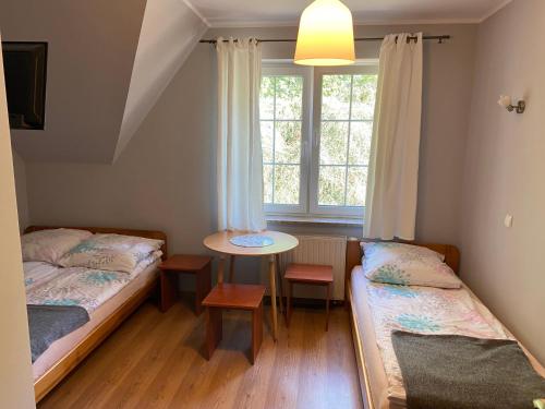 Lewin KłodzkiDańczówka的客房设有两张床、一张桌子和一扇窗户。