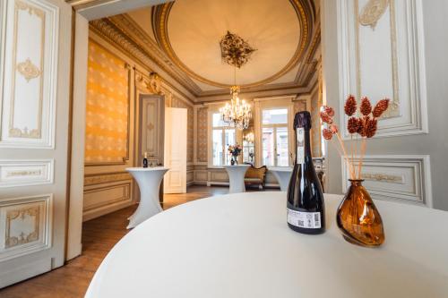 赫伦塔尔斯Luxeverblijf B&B het Wevershuis的一间设有一张桌子的房间,提供两瓶葡萄酒