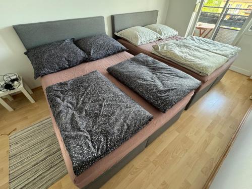 慕尼黑60sqm "Piece of heaven" in Munich's south的卧室内的两张床、毯子和枕头